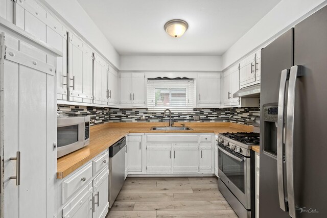 440 Berkshire Ave, Romeoville, IL 60446 - kitchen with stainless steel appliances, a sink, under cabinet range hood, butcher block countertops, and tasteful backsplash
