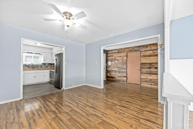 440 Berkshire Ave, Romeoville, IL 60446 - unfurnished living room featuring a sink, wood finished floors, ceiling fan, and baseboards