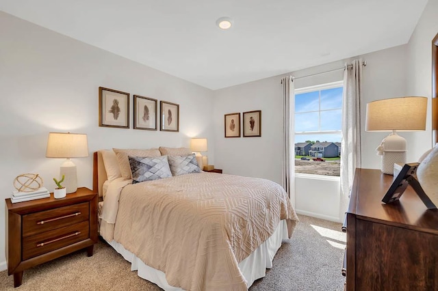 bedroom featuring light colored carpet and baseboards