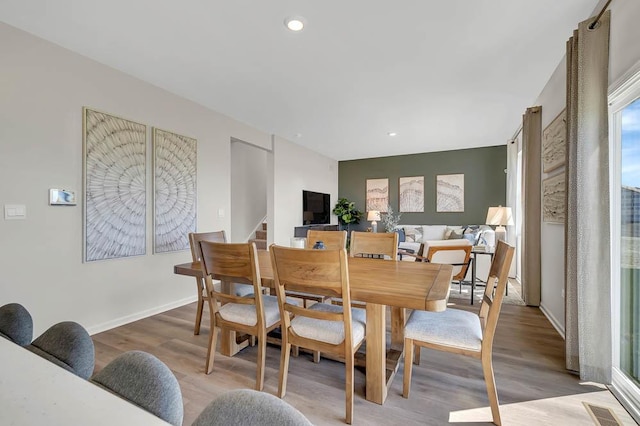 dining space with wood finished floors, stairs, recessed lighting, and baseboards