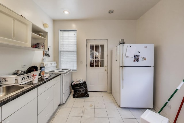 3304 W Warren Blvd, Chicago, IL 60624 - kitchen with white appliances, dark countertops, light tile patterned floors, a sink, and white cabinetry