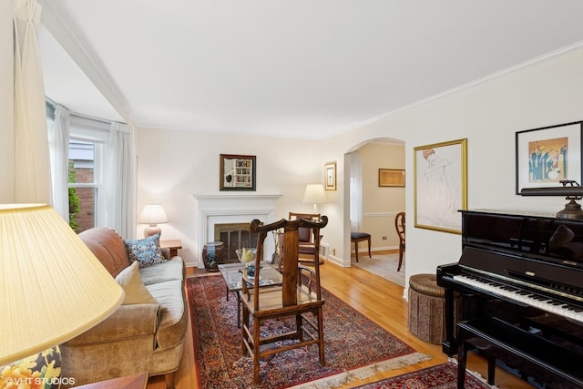 5530 Theobald Rd, Morton Grove, IL 60053 - living area with arched walkways, light wood finished floors, baseboards, ornamental molding, and a fireplace