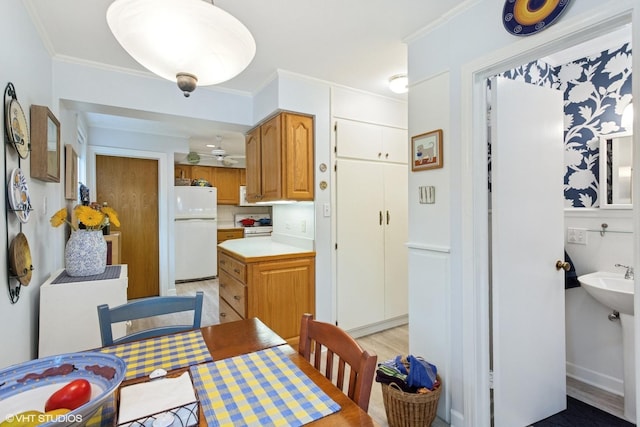 5530 Theobald Rd, Morton Grove, IL 60053 - kitchen with freestanding refrigerator, light countertops, crown molding, and brown cabinetry