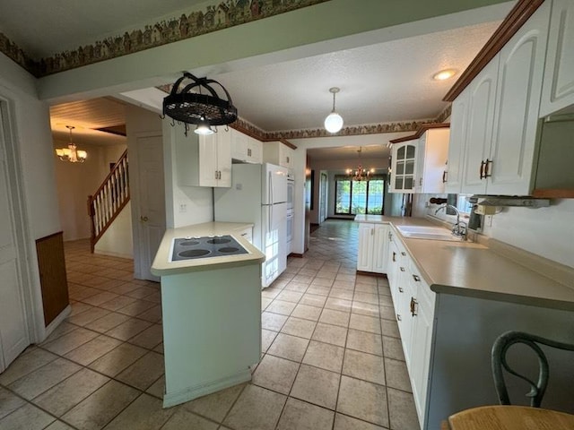 110 Martin Dr, Rock Falls, IL 61071 - kitchen featuring a chandelier, a peninsula, electric cooktop, glass insert cabinets, and white cabinets