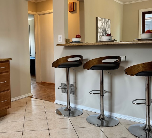 7727 W Palatine Ave, Chicago, IL 60631 - bar with ornamental molding, light tile patterned floors, and baseboards