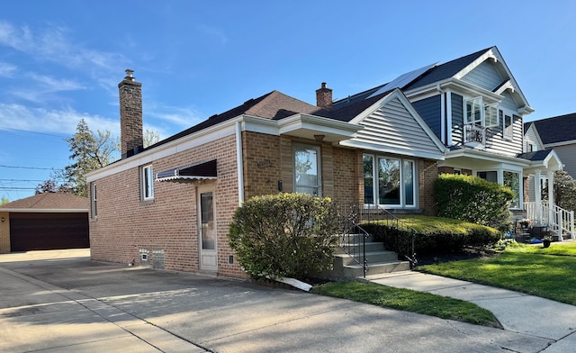 7727 W Palatine Ave, Chicago, IL 60631 - view of front facade featuring brick siding, a chimney, an outbuilding, a garage, and roof mounted solar panels