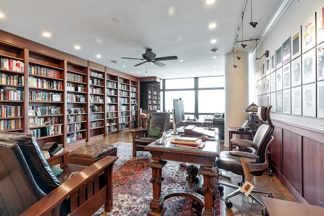 home office featuring ceiling fan, wall of books, recessed lighting, and floor to ceiling windows