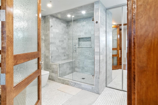 bathroom featuring toilet, a shower stall, and tile walls