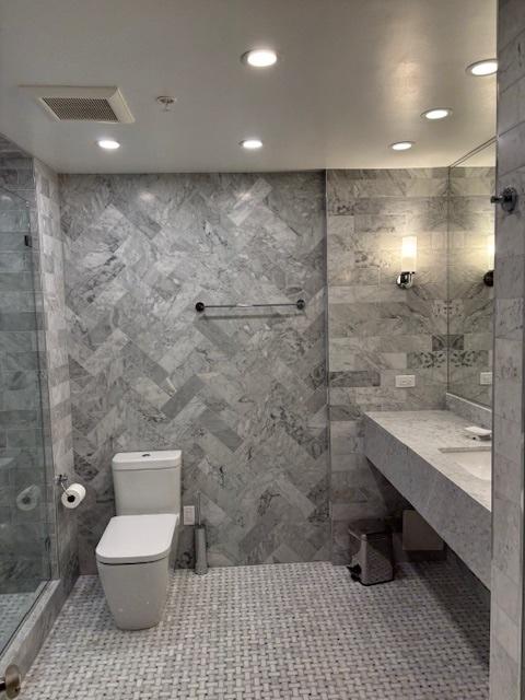 bathroom with tile walls, a stall shower, toilet, recessed lighting, and tile patterned floors