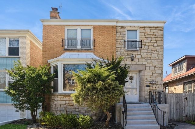 6504 N Artesian Ave, Chicago, IL 60645 - view of front of home featuring a chimney, stone siding, and fence