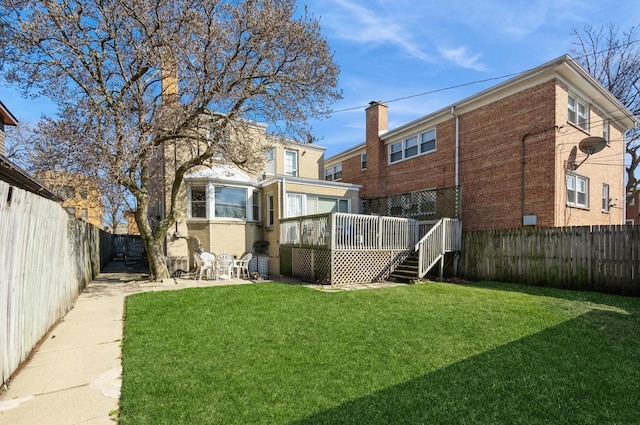 6504 N Artesian Ave, Chicago, IL 60645 - rear view of house featuring a wooden deck, brick siding, and stairs
