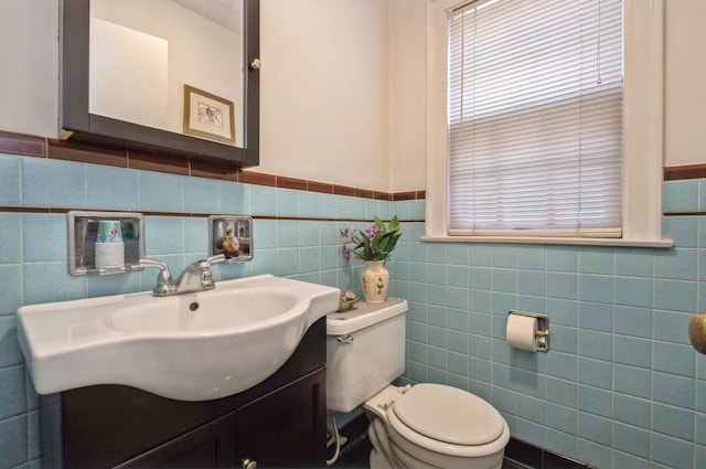 6504 N Artesian Ave, Chicago, IL 60645 - half bathroom featuring tile walls, wainscoting, toilet, and vanity