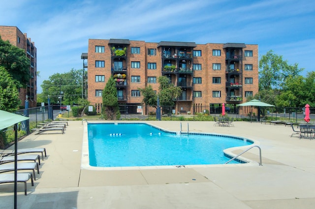 community pool featuring fence and a patio