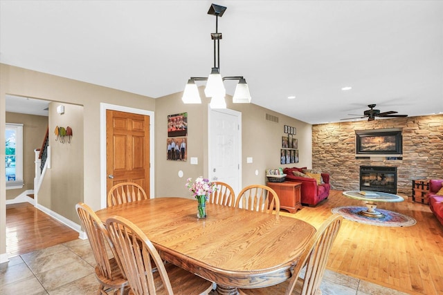 3408 Mill Creek Ct, Champaign, IL 61822 - dining area with a stone fireplace, ceiling fan, baseboards, stairway, and light tile patterned floors