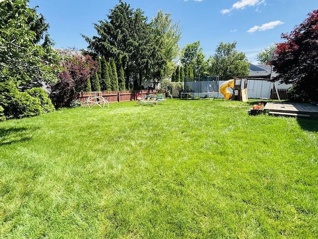 3408 Mill Creek Ct, Champaign, IL 61822 - view of yard featuring a trampoline and a wooden deck