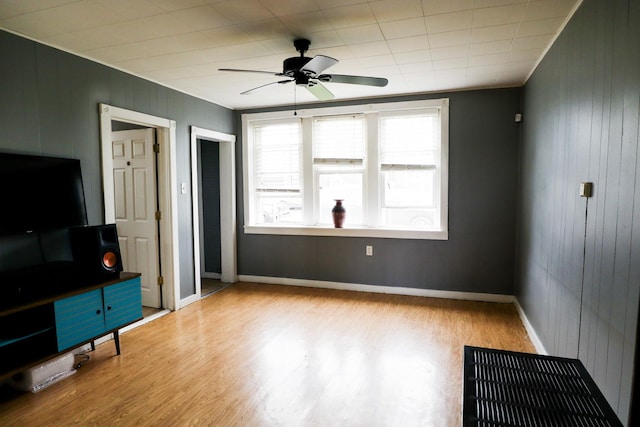 2940 W 38th St, Chicago, IL 60632 - unfurnished living room featuring wood walls, wood finished floors, a ceiling fan, and baseboards