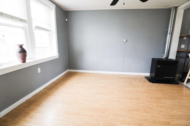 2940 W 38th St, Chicago, IL 60632 - unfurnished room featuring baseboards, a wood stove, ceiling fan, and wood finished floors