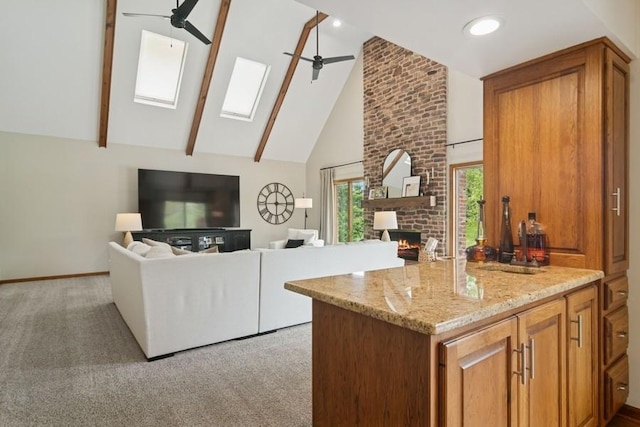 22902 W Lochanora Dr, Hawthorn Woods, IL 60047 - kitchen featuring a ceiling fan, a fireplace, a skylight, high vaulted ceiling, and brown cabinets