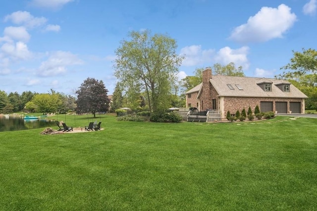 22902 W Lochanora Dr, Hawthorn Woods, IL 60047 - view of grassy yard featuring a garage, a deck, asphalt driveway, and an outdoor fire pit