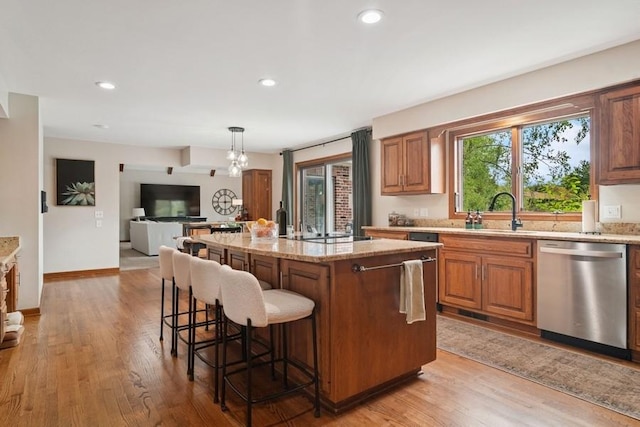 22902 W Lochanora Dr, Hawthorn Woods, IL 60047 - kitchen featuring stainless steel dishwasher, a sink, light stone counters, a kitchen bar, and light wood-style flooring