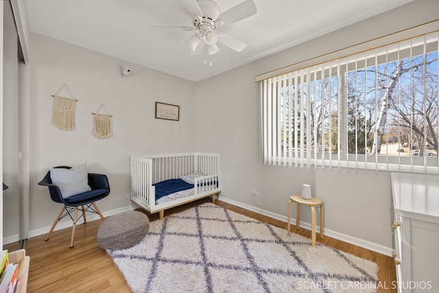 647 Glacier Trl, Roselle, IL 60172 - bedroom with wood finished floors, a crib, and baseboards