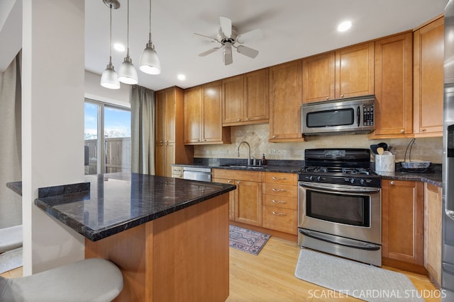 647 Glacier Trl, Roselle, IL 60172 - kitchen with appliances with stainless steel finishes, a sink, light wood-style flooring, a ceiling fan, and brown cabinets