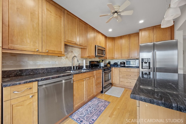 647 Glacier Trl, Roselle, IL 60172 - kitchen with appliances with stainless steel finishes, a sink, light wood-style flooring, ceiling fan, and dark stone countertops