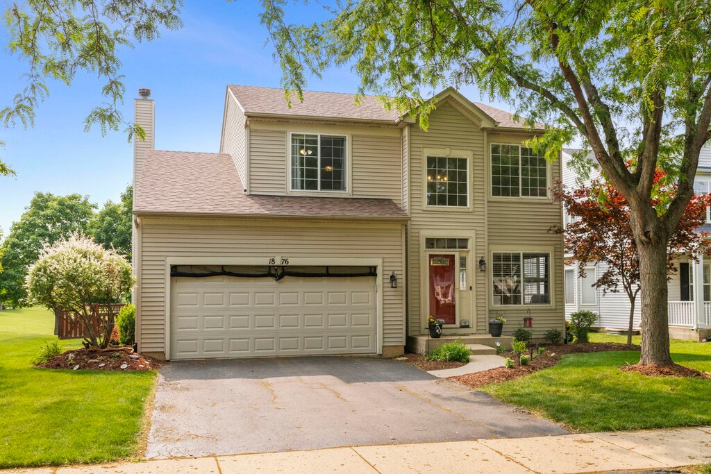 1876 Ione Ln, Aurora, IL 60503 - traditional-style house featuring asphalt driveway, a front yard, a chimney, and an attached garage