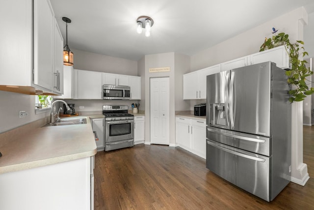 1876 Ione Ln, Aurora, IL 60503 - kitchen featuring appliances with stainless steel finishes, a sink, light countertops, dark wood-style flooring, and white cabinetry