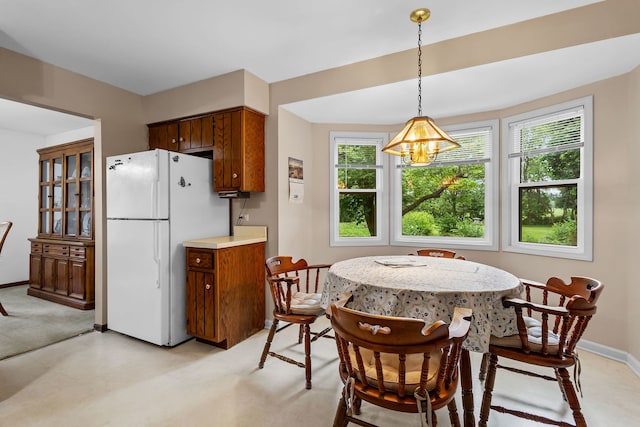 2841 E Pine Dr, Crete, IL 60417 - kitchen featuring freestanding refrigerator, brown cabinetry, light countertops, and hanging light fixtures