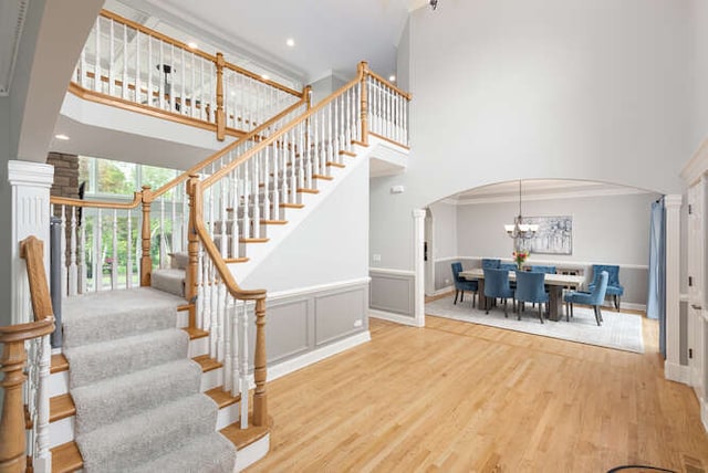 3211 Treyburn Rd, Naperville, IL 60564 - stairs with a towering ceiling, arched walkways, a chandelier, wood finished floors, and baseboards