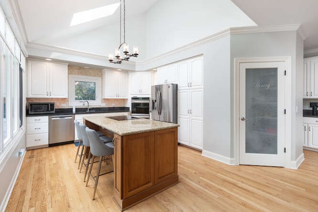 3211 Treyburn Rd, Naperville, IL 60564 - kitchen with stainless steel appliances, a chandelier, a skylight, light wood-style flooring, and a kitchen bar