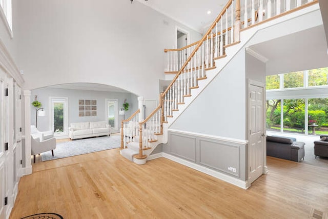 3211 Treyburn Rd, Naperville, IL 60564 - entryway featuring a towering ceiling, arched walkways, wood finished floors, and stairs