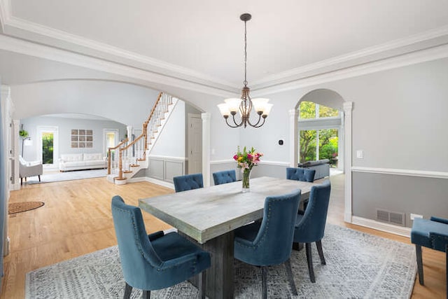 3211 Treyburn Rd, Naperville, IL 60564 - dining area with arched walkways, a chandelier, wood finished floors, stairway, and ornate columns