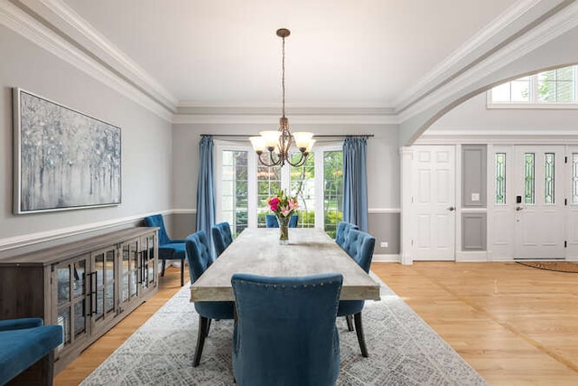 3211 Treyburn Rd, Naperville, IL 60564 - dining space featuring a chandelier, plenty of natural light, light wood-style flooring, crown molding, and arched walkways