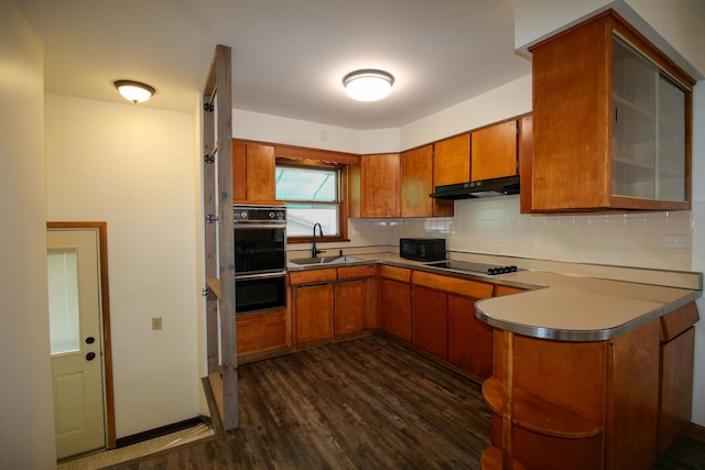 3743 E 112th St, Chicago, IL 60617 - kitchen with a sink, brown cabinetry, a peninsula, black appliances, and under cabinet range hood