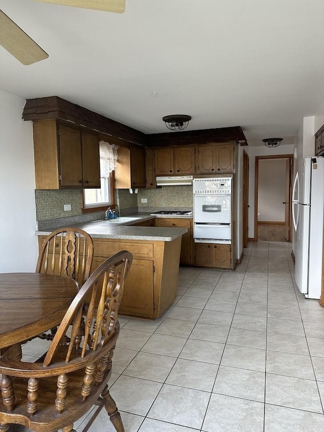 7804 Newland Ave, Burbank, IL 60459 - kitchen with white appliances, under cabinet range hood, a warming drawer, a peninsula, and tasteful backsplash