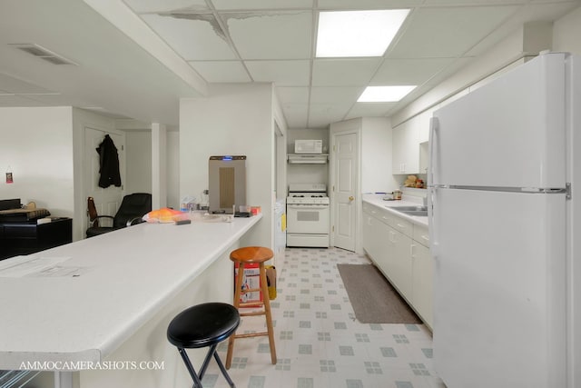 2N562 Atlantic Dr, West Chicago, IL 60185 - kitchen featuring white appliances, light flooring, white cabinets, under cabinet range hood, and a kitchen breakfast bar