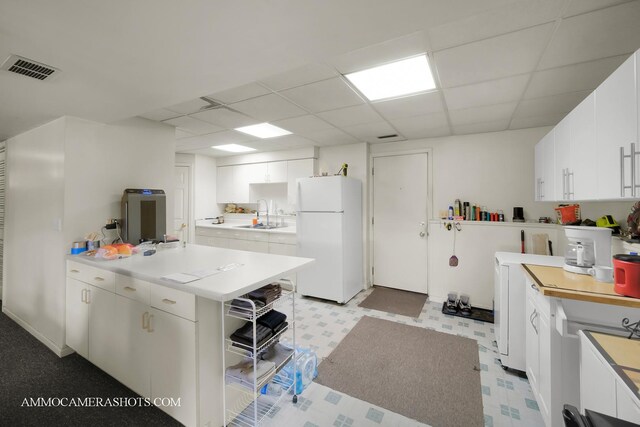2N562 Atlantic Dr, West Chicago, IL 60185 - kitchen with freestanding refrigerator, a paneled ceiling, light floors, light countertops, and white cabinets