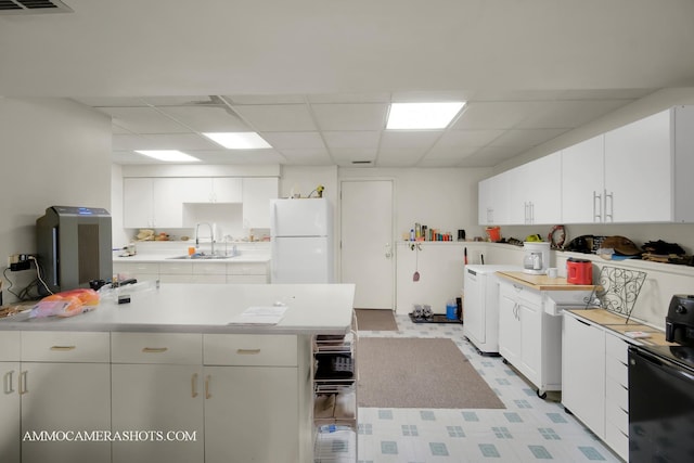 2N562 Atlantic Dr, West Chicago, IL 60185 - kitchen featuring freestanding refrigerator, a sink, light countertops, washer / dryer, and a drop ceiling