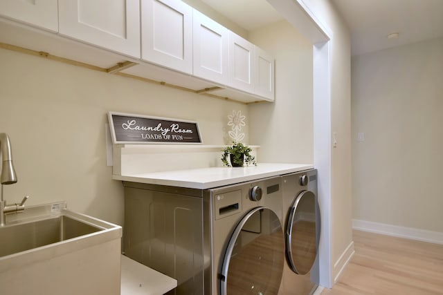 15608 Petunia Ct, Orland Park, IL 60462 - clothes washing area featuring washing machine and dryer, cabinet space, light wood-style floors, and baseboards