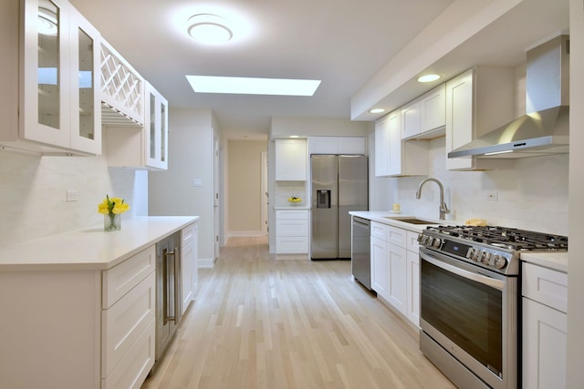 15608 Petunia Ct, Orland Park, IL 60462 - kitchen featuring stainless steel appliances, wall chimney range hood, a sink, a skylight, and tasteful backsplash
