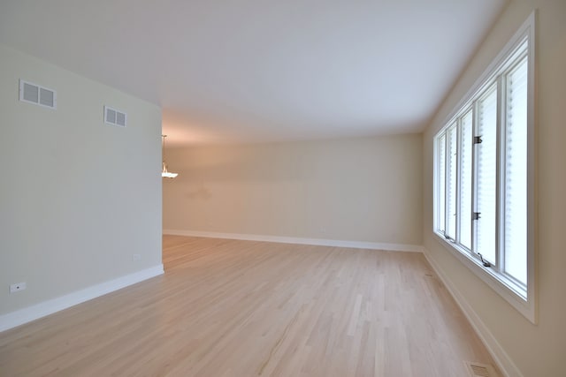 15608 Petunia Ct, Orland Park, IL 60462 - empty room featuring a chandelier, light wood-style floors, and baseboards