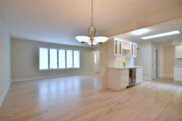 15608 Petunia Ct, Orland Park, IL 60462 - kitchen with beverage cooler, a chandelier, light wood-style flooring, and baseboards