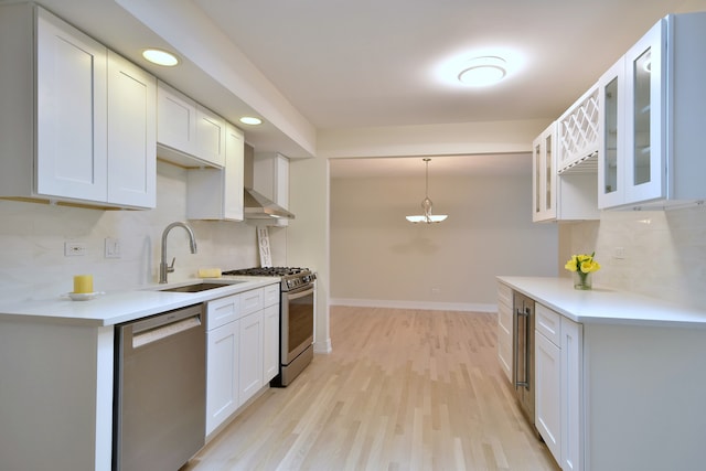 15608 Petunia Ct, Orland Park, IL 60462 - kitchen with appliances with stainless steel finishes, a sink, light wood-type flooring, tasteful backsplash, and glass insert cabinets