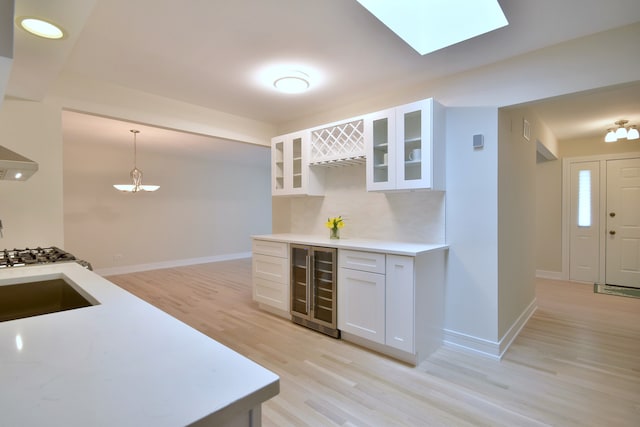 15608 Petunia Ct, Orland Park, IL 60462 - kitchen featuring wine cooler, light wood-style floors, white cabinetry, and light countertops
