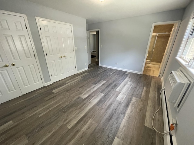 1238 W Pratt Blvd Unit 1A, Chicago, IL 60626 - unfurnished bedroom featuring dark wood-style flooring, two closets, ensuite bathroom, and a wall mounted AC