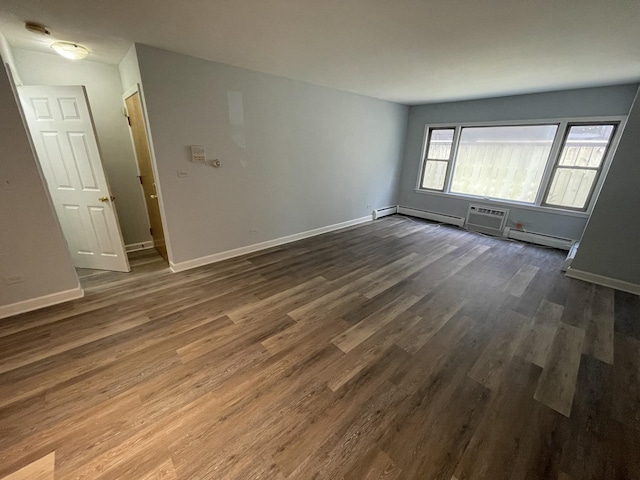 1238 W Pratt Blvd Unit 1A, Chicago, IL 60626 - spare room featuring dark wood finished floors, a wall unit AC, and a baseboard heating unit