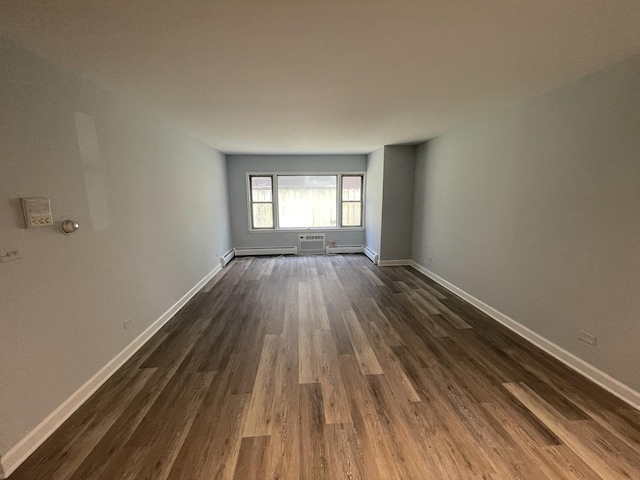1238 W Pratt Blvd Unit 1A, Chicago, IL 60626 - spare room with dark wood-style flooring, a wall mounted AC, and a baseboard radiator