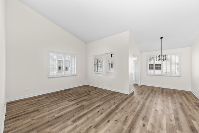 1468 W Grand Haven Rd, Romeoville, IL 60446 - unfurnished living room with a chandelier, light wood-style flooring, high vaulted ceiling, and baseboards